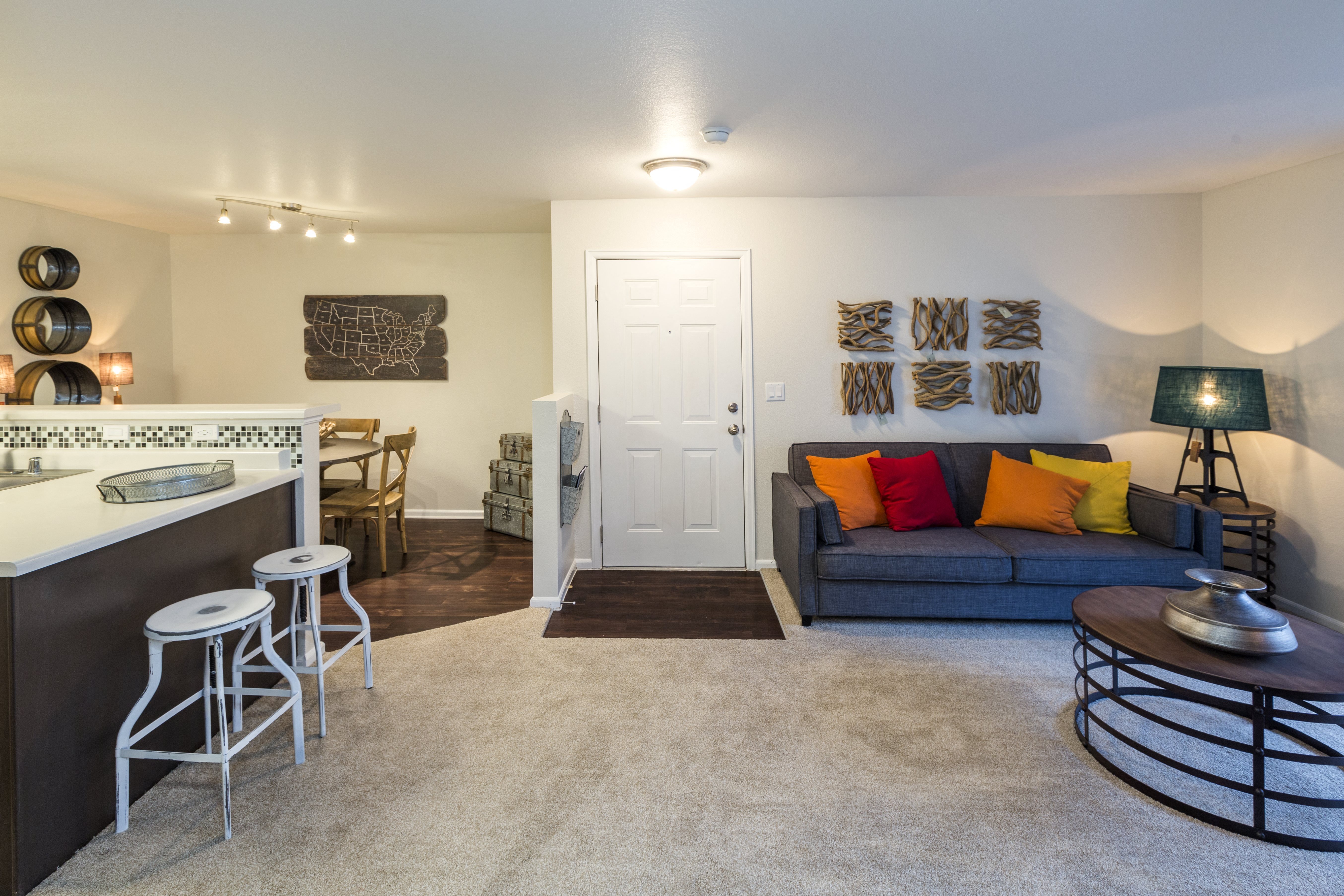 a living room with a couch and a kitchen with a bar